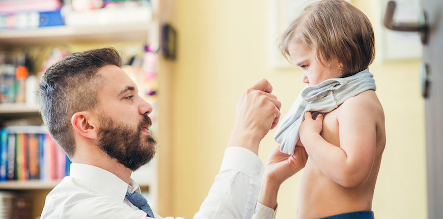 Young father getting his little daughter ready in a morning