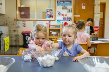 Two little girls developing their fine motor skills at preschool